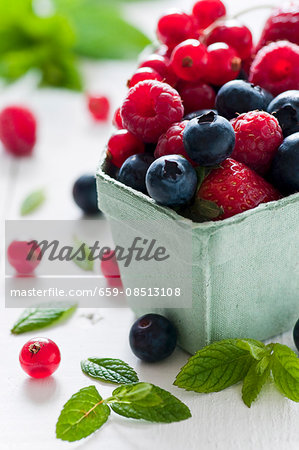 Fresh berries berries and fresh mint leaves in a cardboard punnet Fresh berries berries and fresh mint leaves in a cardboard punnet