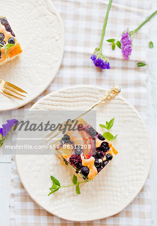 Two pieces of fruit cake on a plate with a silver fork