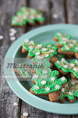 Gingerbread Christmas tree biscuits with green icing on a plate