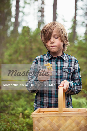 Boy holding mushroom and basket