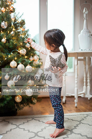 Toddler girl decorating Christmas tree