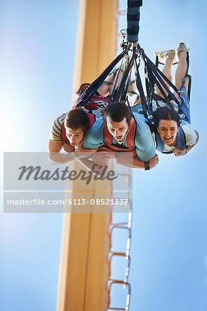 Friends bungee jumping at amusement park