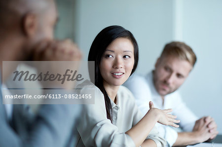 Businesswoman gesturing and talking in meeting Businesswoman gesturing and talking in meeting