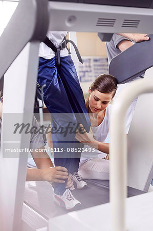 Physical therapists guiding man on treadmill
