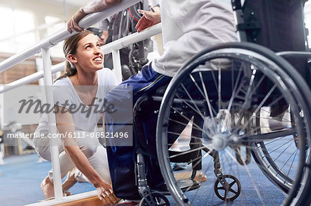 Physical therapist preparing man in wheelchair