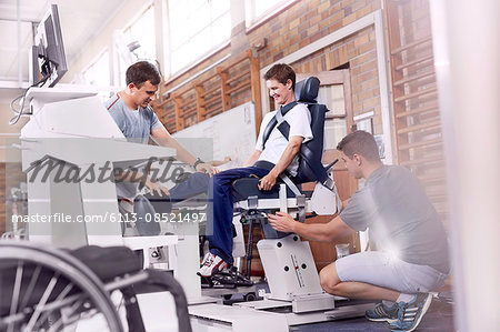 Physical therapists guiding man using equipment