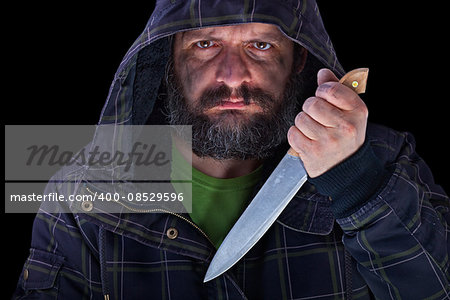 Hooded frightening man in the dark with dirty face and big knife