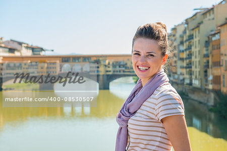 Remarkable holiday in Florence. Portrait of smiling young tourist standing on the bridge overlooking Ponte Vecchio