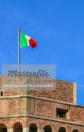 italy flag on an old fortress fluttering in the wind in the rays of the setting sun