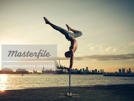 Mature man doing handstand on pole, South Pointe Park, South Beach, Miami, Florida, USA