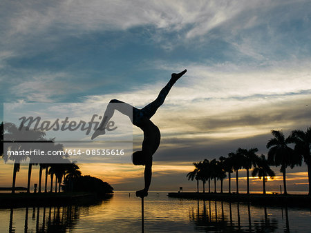 Mature man balancing on pole, dusk, South Pointe Park, South Beach, Miami, Florida, USA