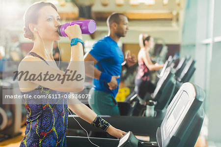 Woman on treadmill drinking water