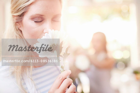 Woman smelling white gerber daisy