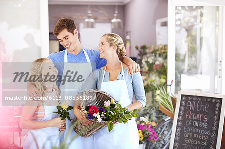 Florists smiling and hugging in flower shop