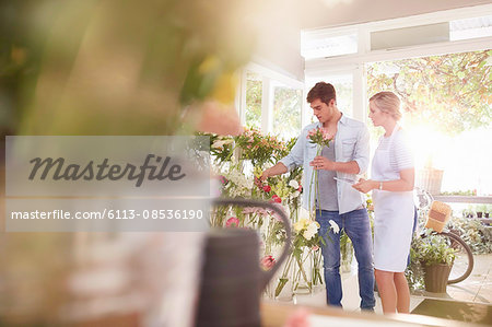 Florist helping man choosing flowers in flower shop