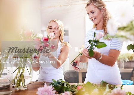 Smiling florists arranging bouquet in flower shop