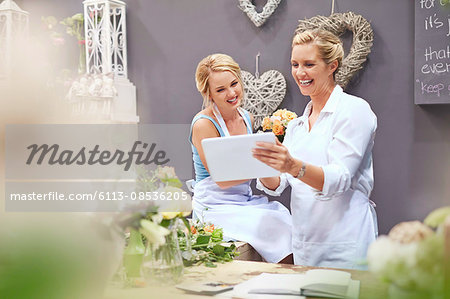 Smiling florists using digital tablet in flower shop