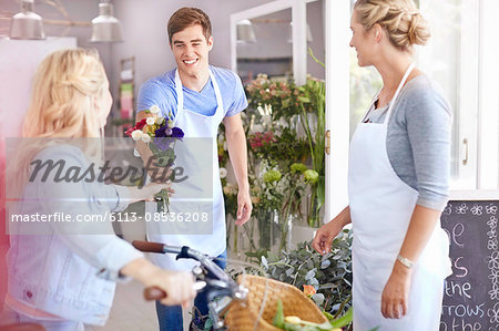 Florist giving customer bouquet in flower shop