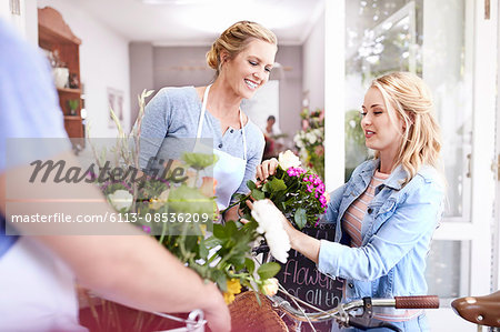 Florist helping woman pick out flowers in flower shop