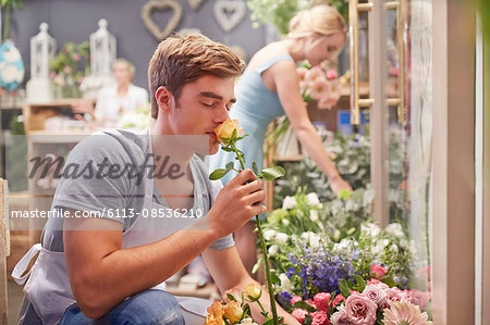 Florist smelling rose in flower shop