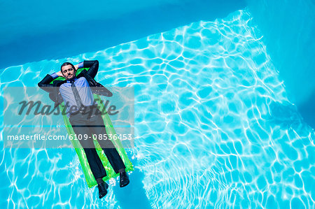 Businessman relaxing on inflatable Businessman relaxing on inflatable