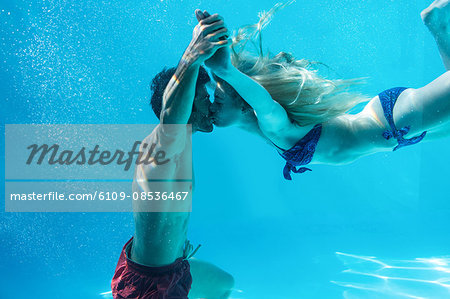 Happy couple kissing underwater