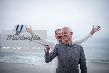 Senior couple taking a selfie on the beach