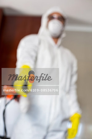 Low angle view of worker holding sprayer