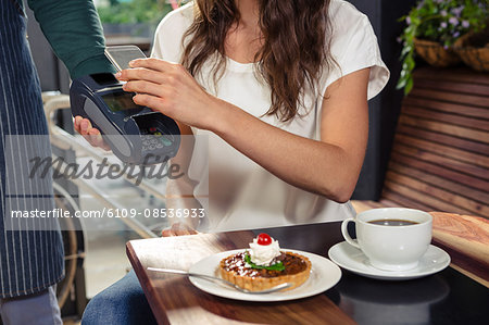 Woman paying with her smartphone