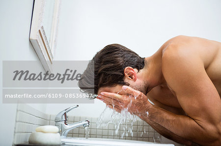 Man washing his face in the bathroom