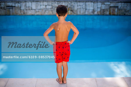 Shirtless boy standing in swimming pool