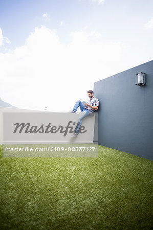 Man sitting on terrace using digital tablet
