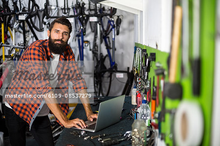 Bike mechanic checking at laptop
