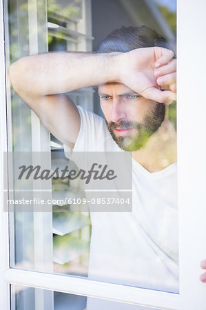 Depressed man leaning his head on window glass