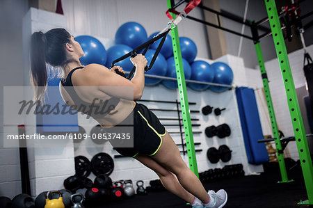 Woman doing suspension training with trx fitness straps