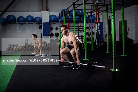 Man and woman lifting barbell