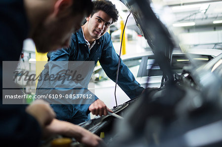 Mechanics examining car engine