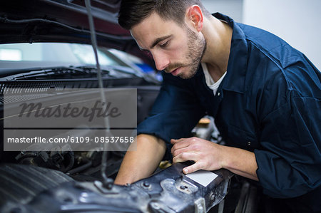 Mechanic examining car engine