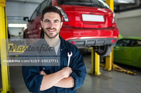 Mechanic with arms crossed and spanner