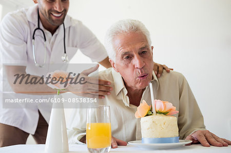 Senior man celebrating his birthday with a cake