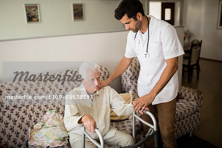 Nurse helping senior man to stand up