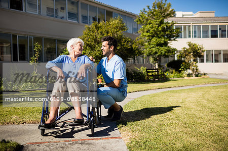 Nurse pushing the senior womans wheelchair Nurse pushing the senior womans wheelchair