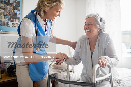 Nurse helping senior woman to stand up