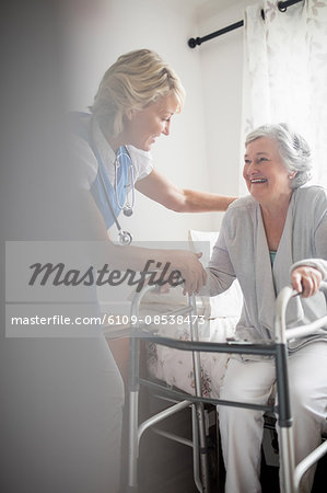 Nurse helping senior woman to stand up