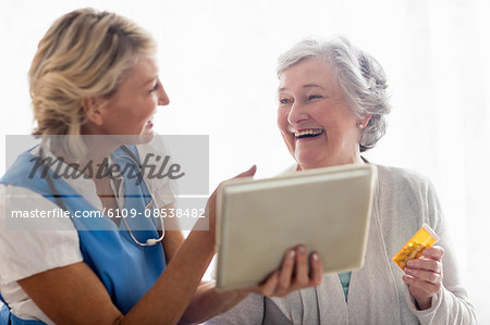 Nurse showing a tablet to a senior woman