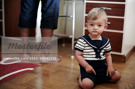 Baby boy pointing towards hardwood floor