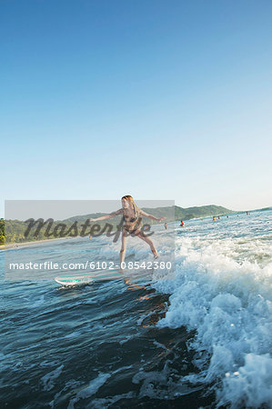 Teenage girl surfing on sea