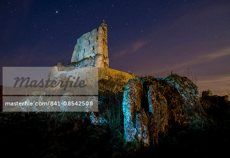 View of rocks and Mirow Castle ruins illuminated at night, Polish Jura, Poland, Europe