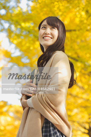 Young Japanese woman with book in a city park