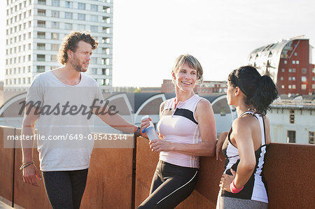 Two women and man training, chatting on footbridge